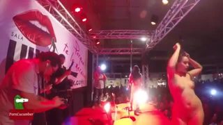 Two hot girls fuck a guy in a the stage of a public festival full of people